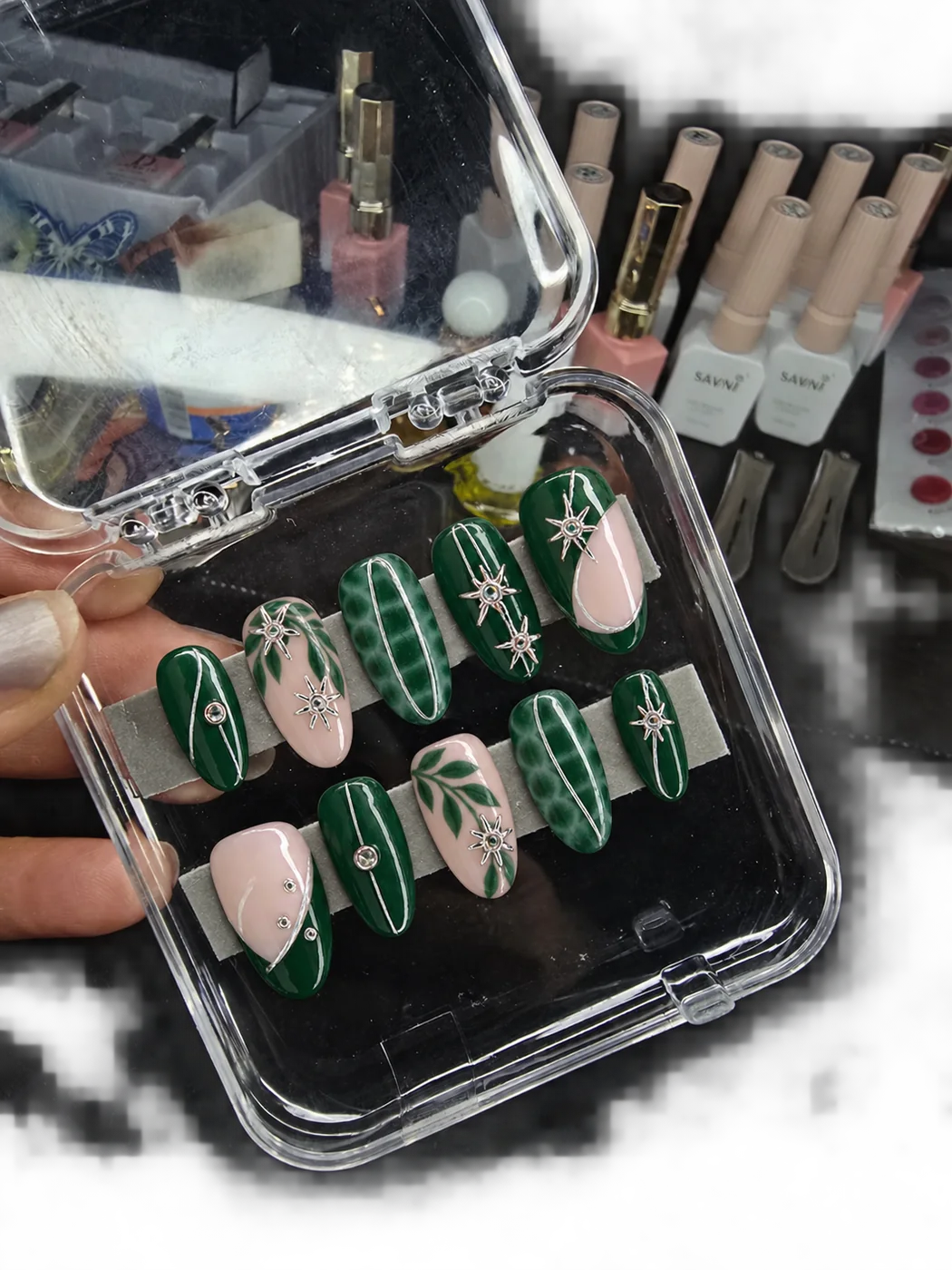 Green and burgundy custom press-on nail sets in a clear tray